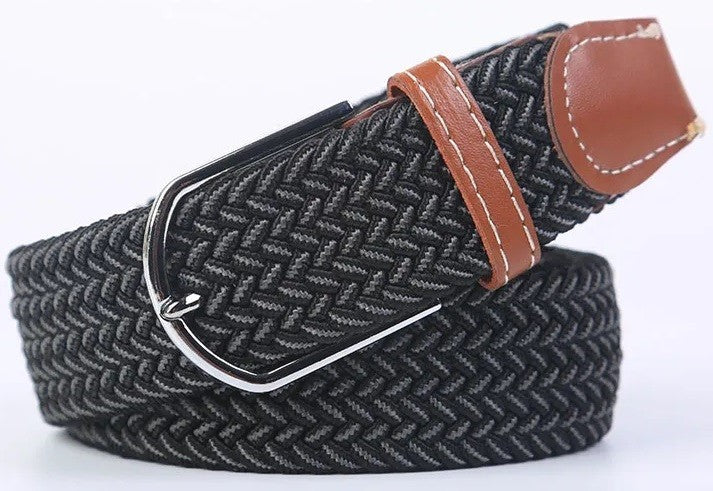 A woven elastic belt with a black and gray herringbone pattern, a brown leather keeper loop with white stitching, and a silver metal buckle, shown on a white background.
