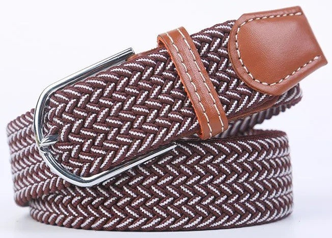 A woven elastic belt with a brown and white herringbone pattern, a brown leather keeper loop, and a silver metal buckle, shown on a white background.